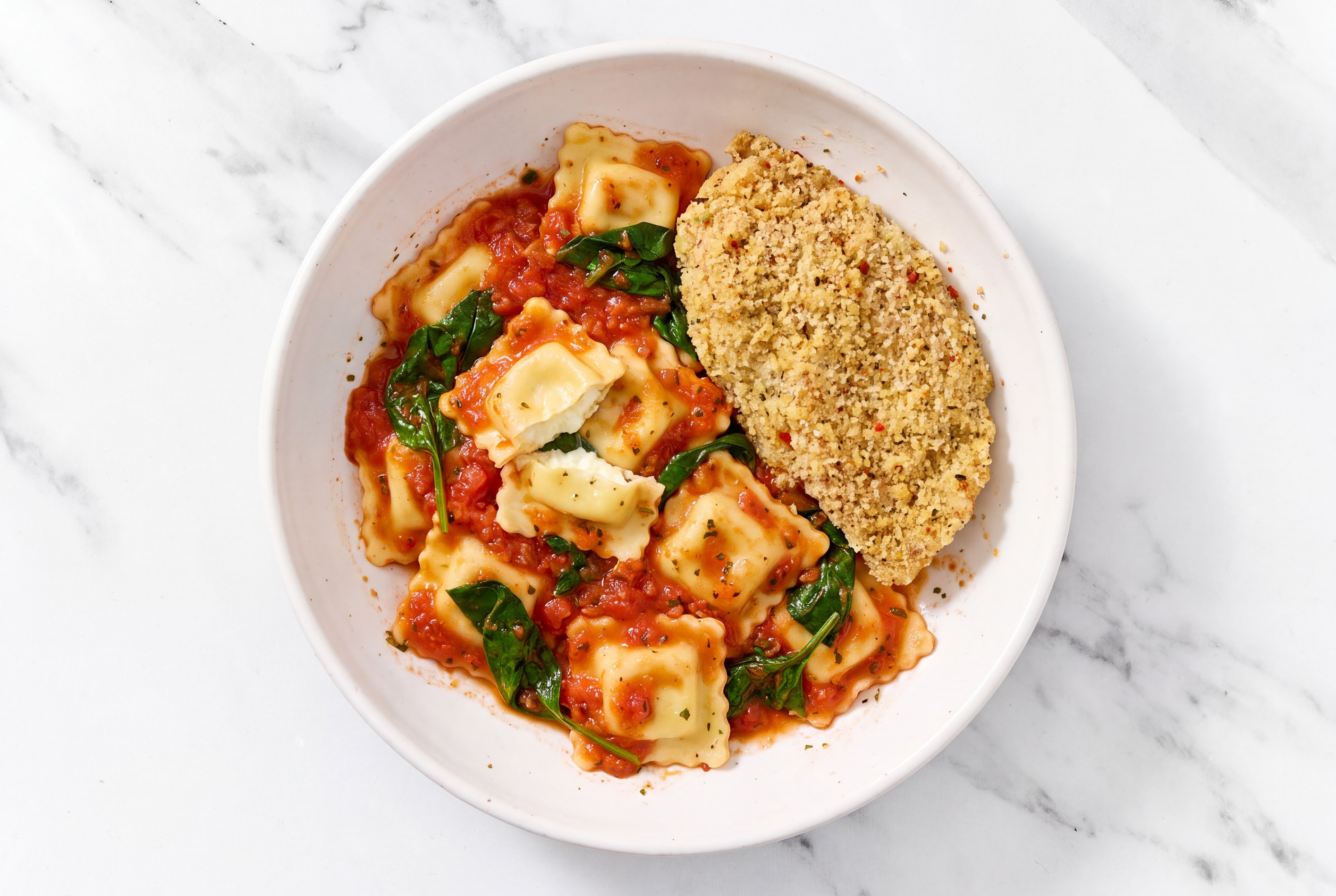 Crispy Garlic Chicken over Marinara Ravioli with Baby Spinach