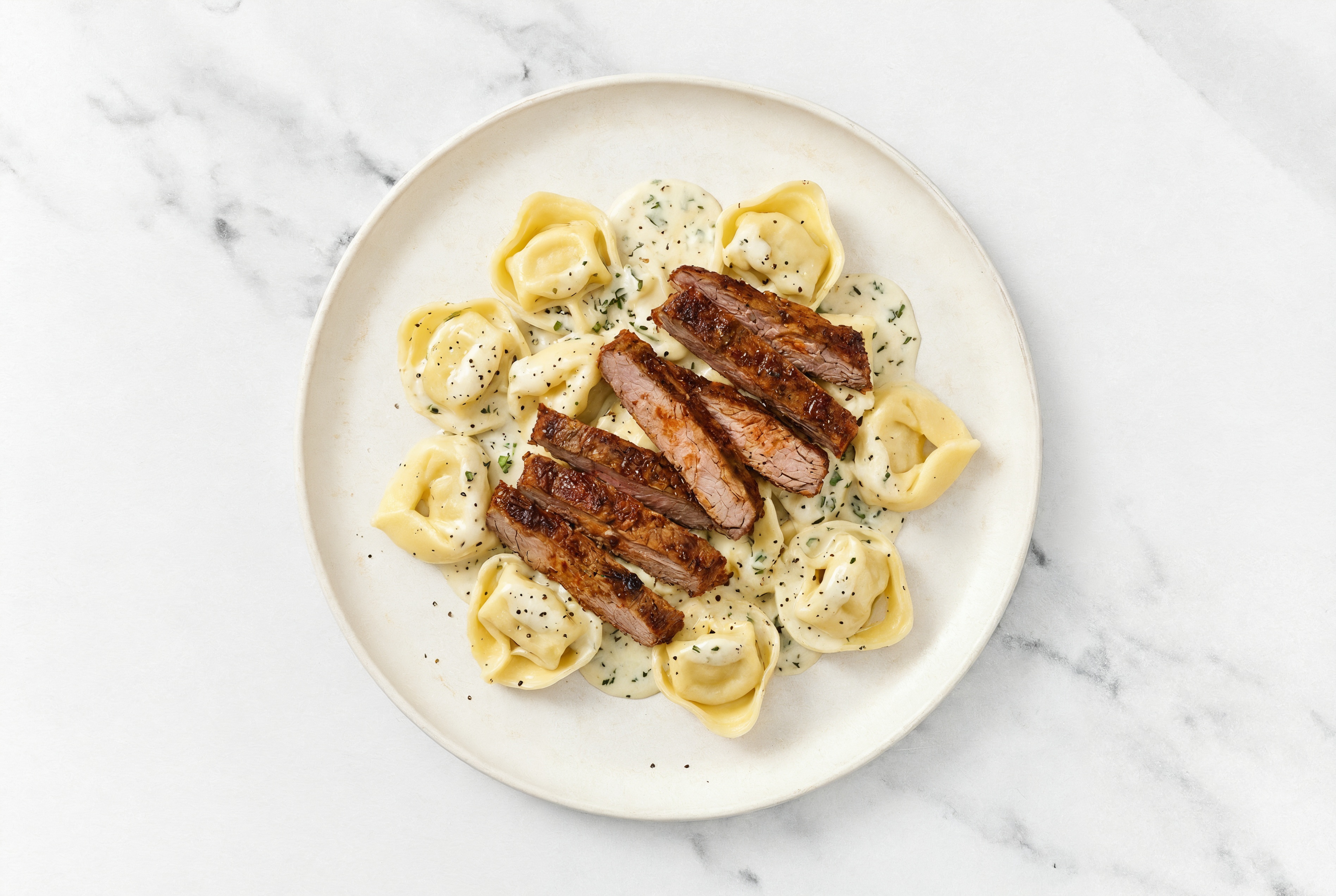 Steakhouse Cheese Tortelloni Herb Cream with Adobo Marinated Flank Steak