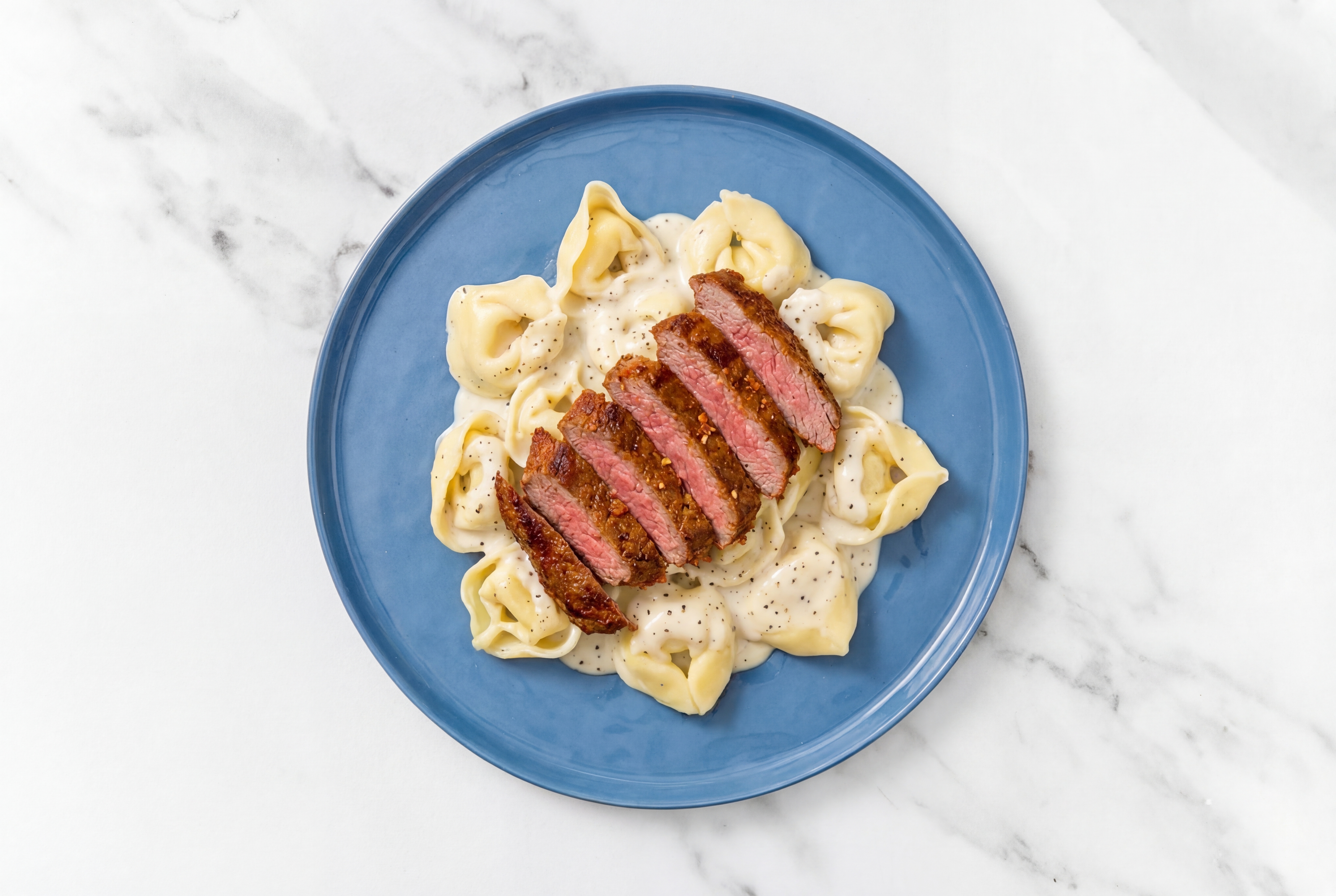 Steakhouse Tortelloni Alfredo with Adobo Marinated Flank Steak
