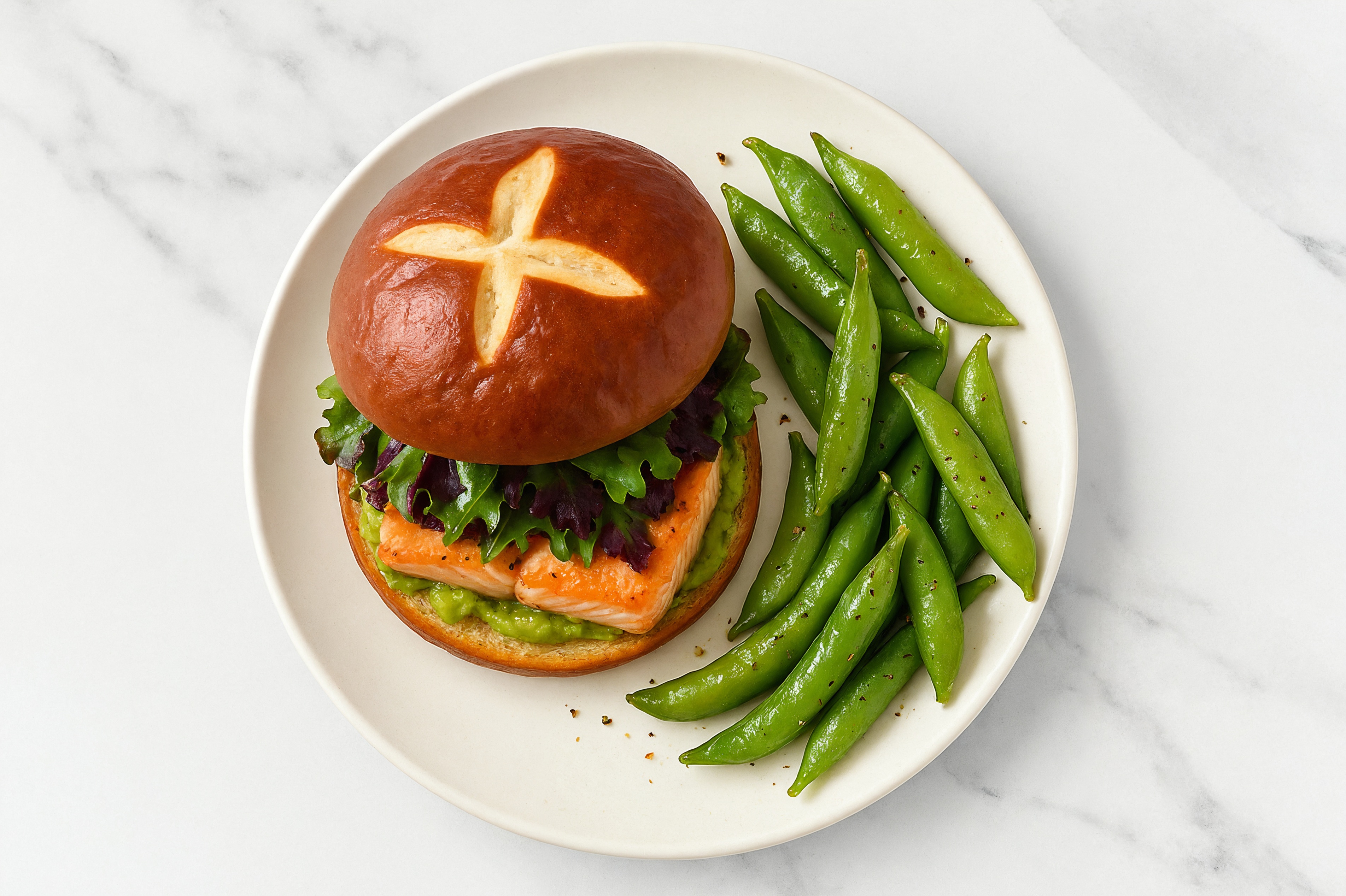 Guac' Salmon Sandwich on Pretzel Bun with Spring Mix + Snap Peas
